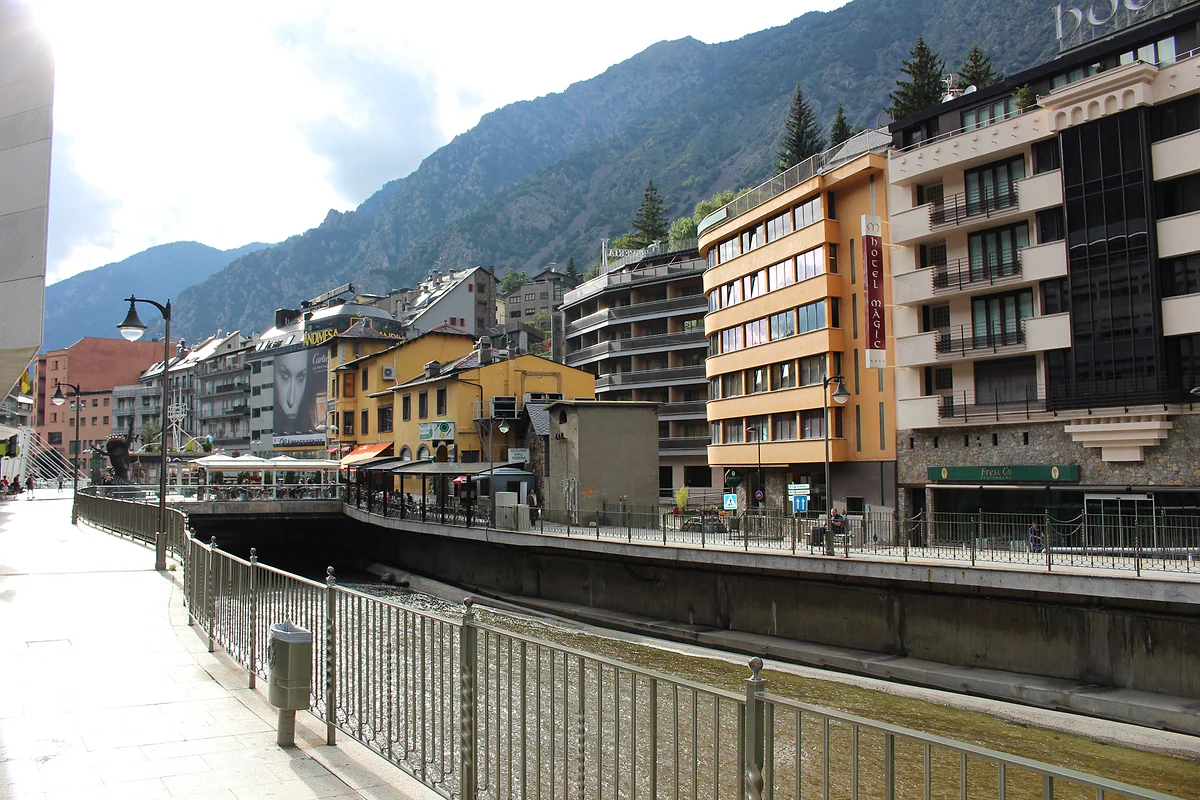Paseo junto al río Valira en Andorra la Vella, con hoteles y edificios de colores bajo las montañas