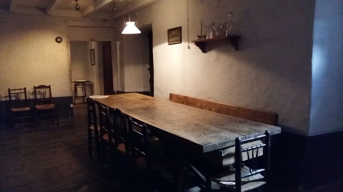 Comedor de la Casa Rull de Sispony, con mesa larga de madera, sillas de enea y paredes encaladas