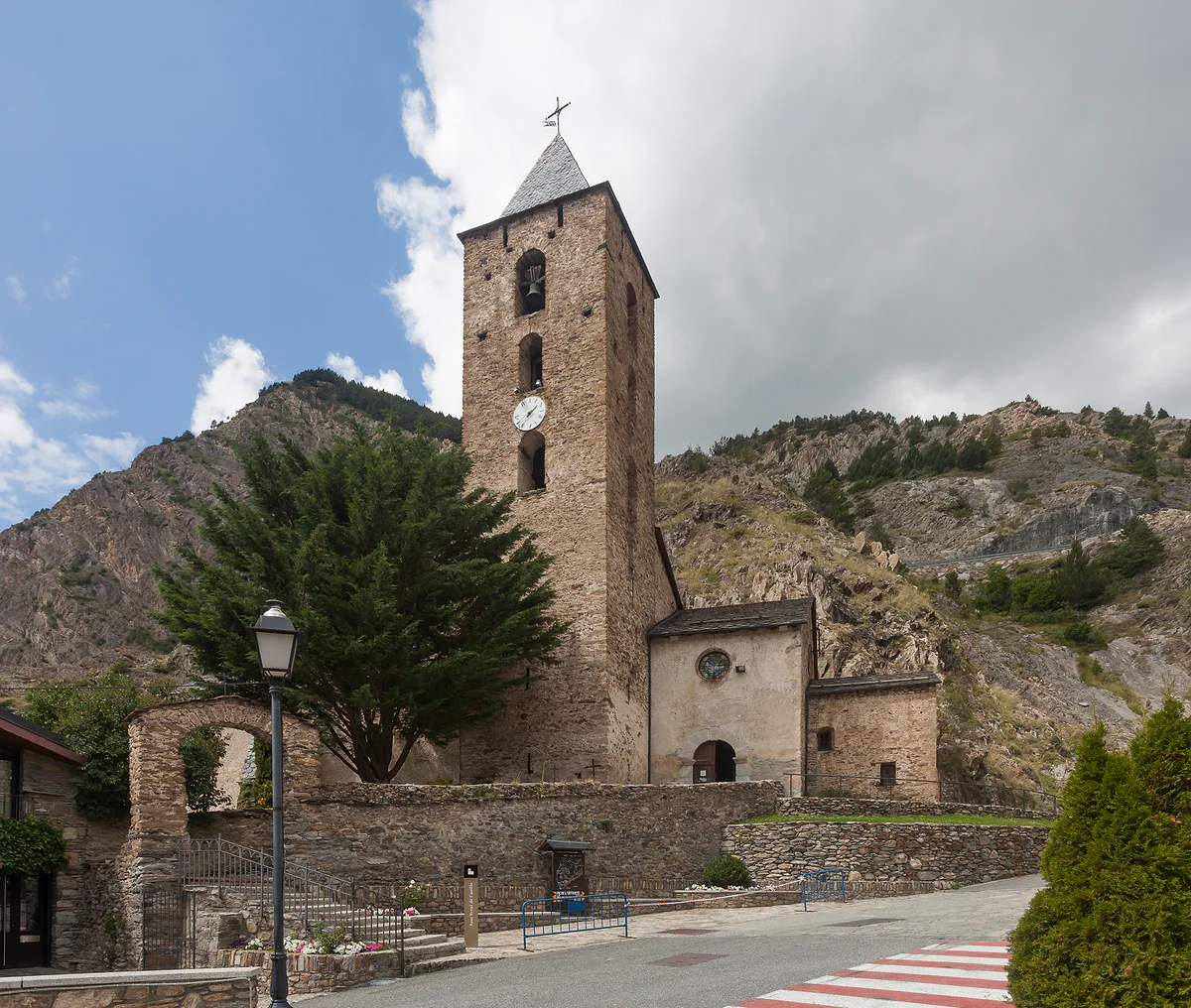 Iglesia de Sant Serni de Canillo, con su alto campanario y las laderas rocosas detrás