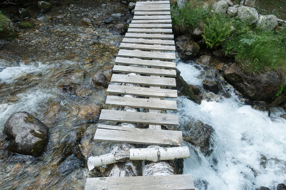 Pasarela de troncos sobre el riu de Claror, en una ruta de senderismo del valle del Madriu