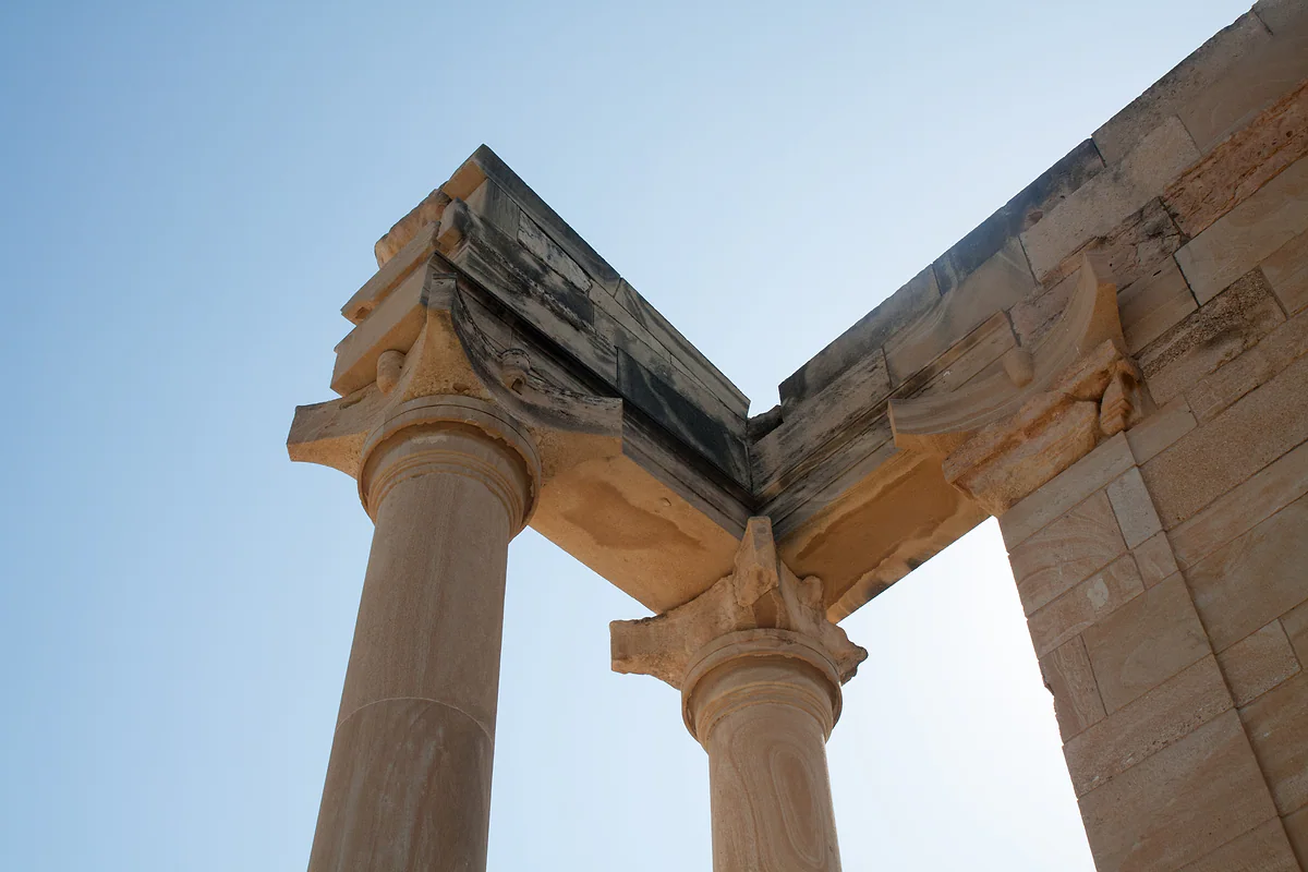 The columns and capitals of the Temple of Apollo Hylates seen from below, against a clear blue sky in Cyprus