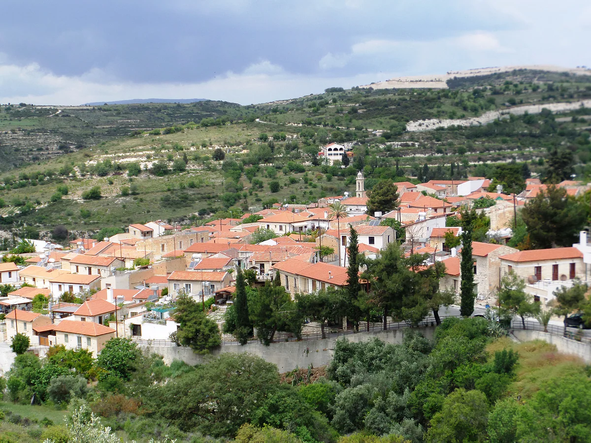 Arsos, a Limassol wine village, with stone houses and red roofs packed close together and the bell tower among cypresses
