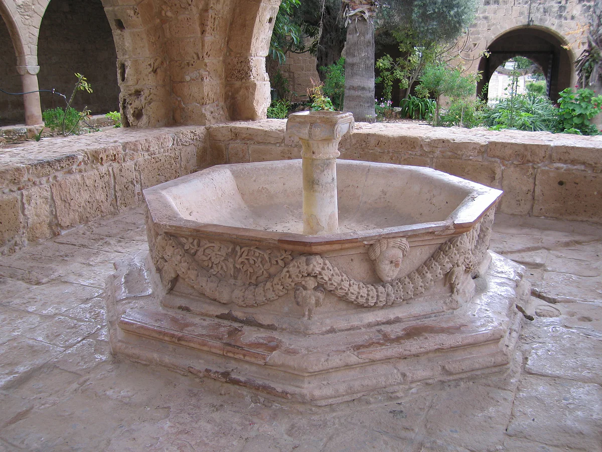 The octagonal marble fountain of Ayia Napa monastery, with garlands carved on its sides, in the middle of its stone courtyard