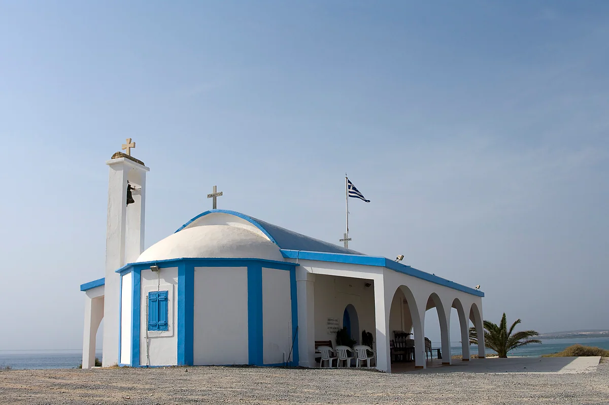 The white chapel of Agia Thekla, with a blue dome and arches, by the beach of the same name west of Ayia Napa in Cyprus