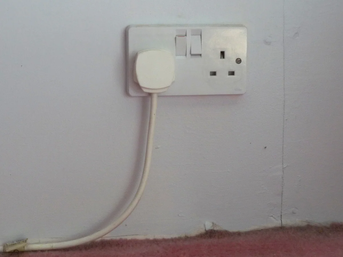 A double type G wall socket with three rectangular pins and switches, one with a plug in, the same standard used in Cyprus as in the UK