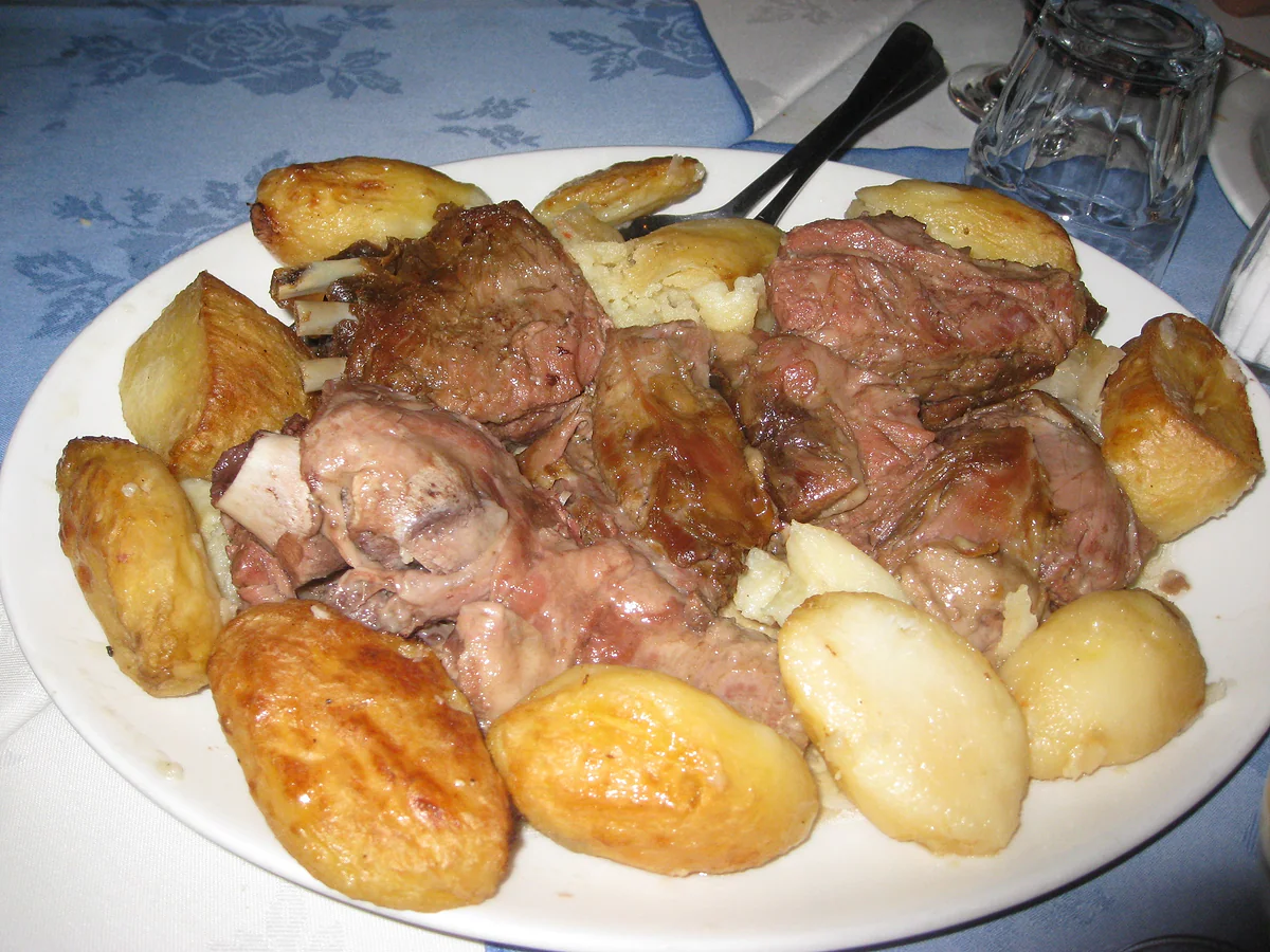 A portion of kleftiko served at a restaurant in Limassol, with the roast meat and golden potatoes on the plate
