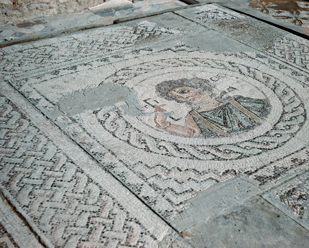 A Roman mosaic at Kourion with a bust inside a medallion, surrounded by geometric borders made of small tesserae