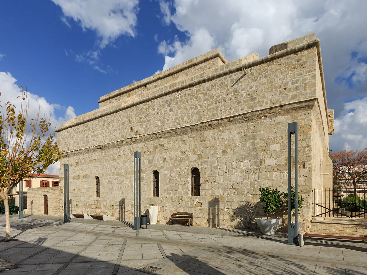 Limassol's medieval castle, a solid building of pale stone by the old port, under a sky with scattered clouds