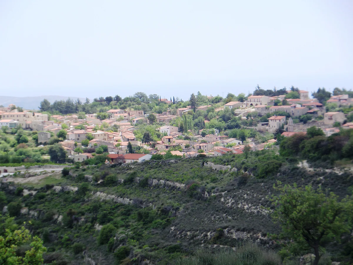 Lofou on top of its hill, with stone houses stepped up the slope and old farming terraces below the village