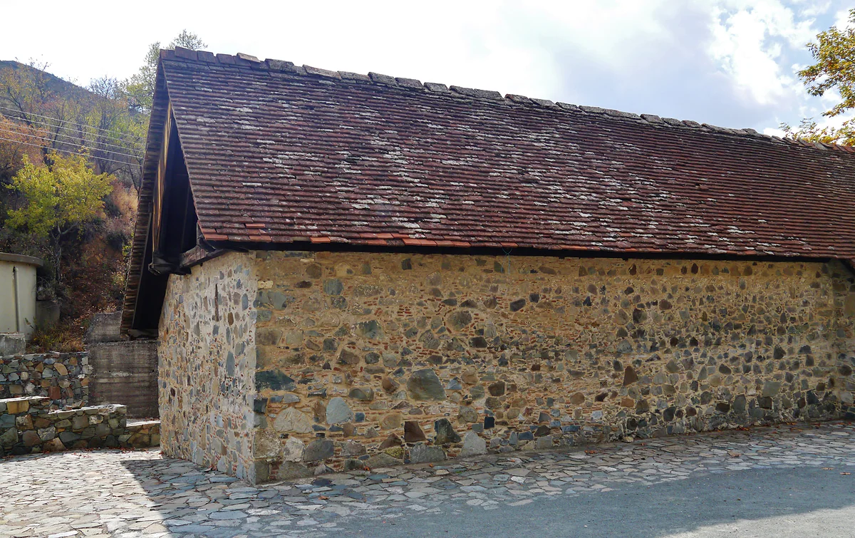 The church of the Transfiguration of the Saviour in Palaichori, built of stone with a pitched timber roof, from the side