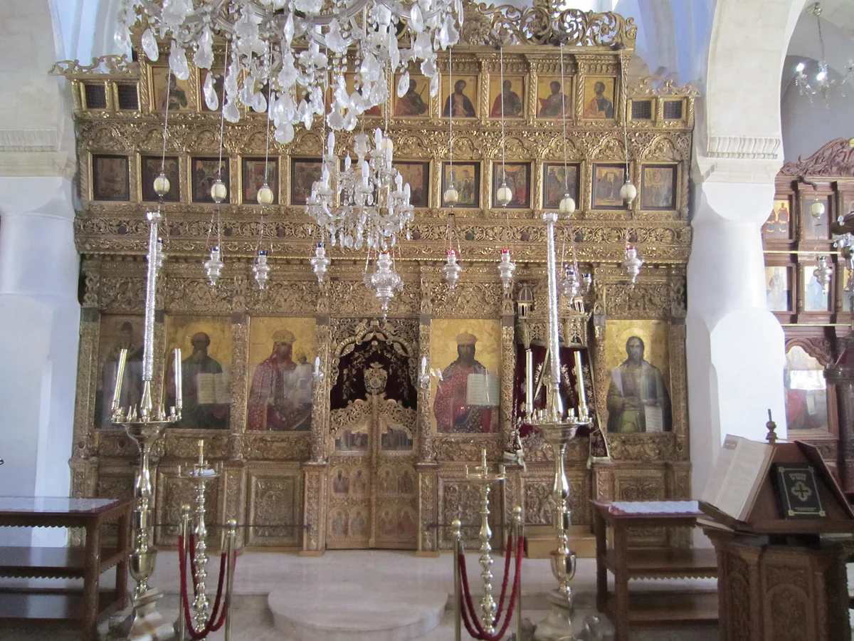The carved gilt iconostasis inside the church of the Holy Cross in Omodos, with icons, silver lamps and candlesticks