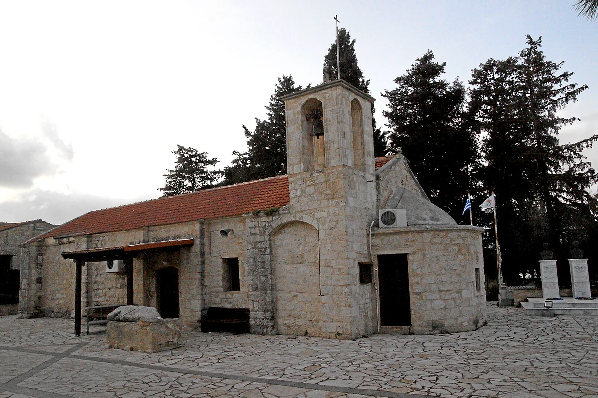 The church of Agios Kalandionas in Pano Arodes, built of stone with a tiled roof and bell tower, in a paved yard among cypresses