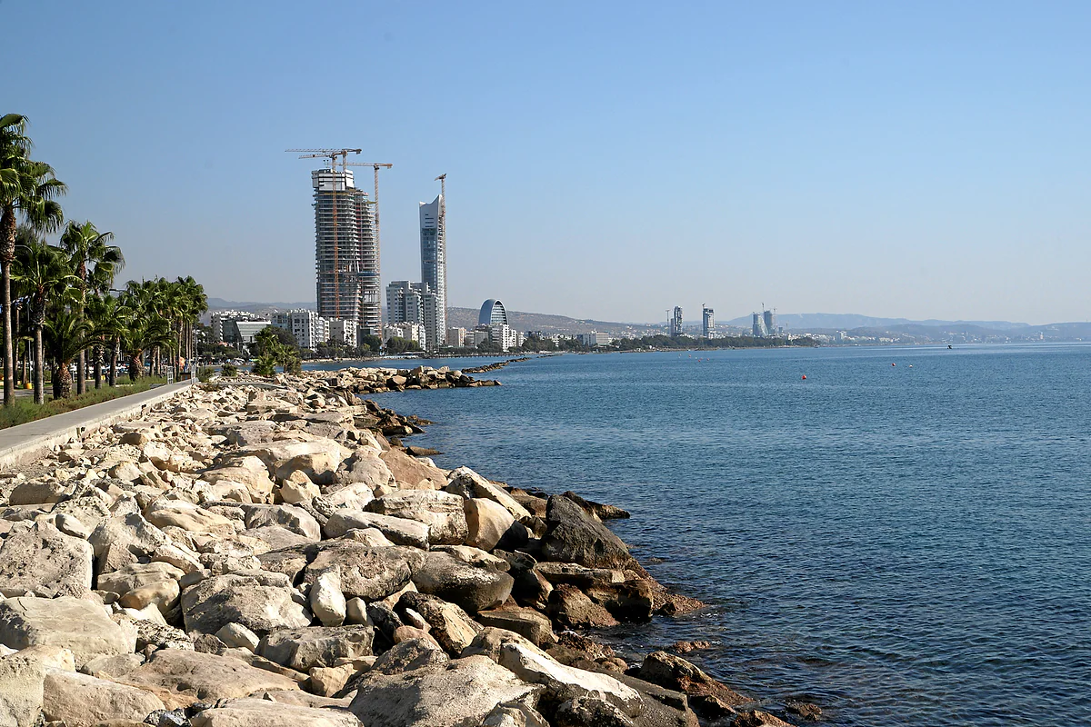 The Molos seafront promenade in Limassol, with palm trees, lawns and the sea on one side and city buildings on the other