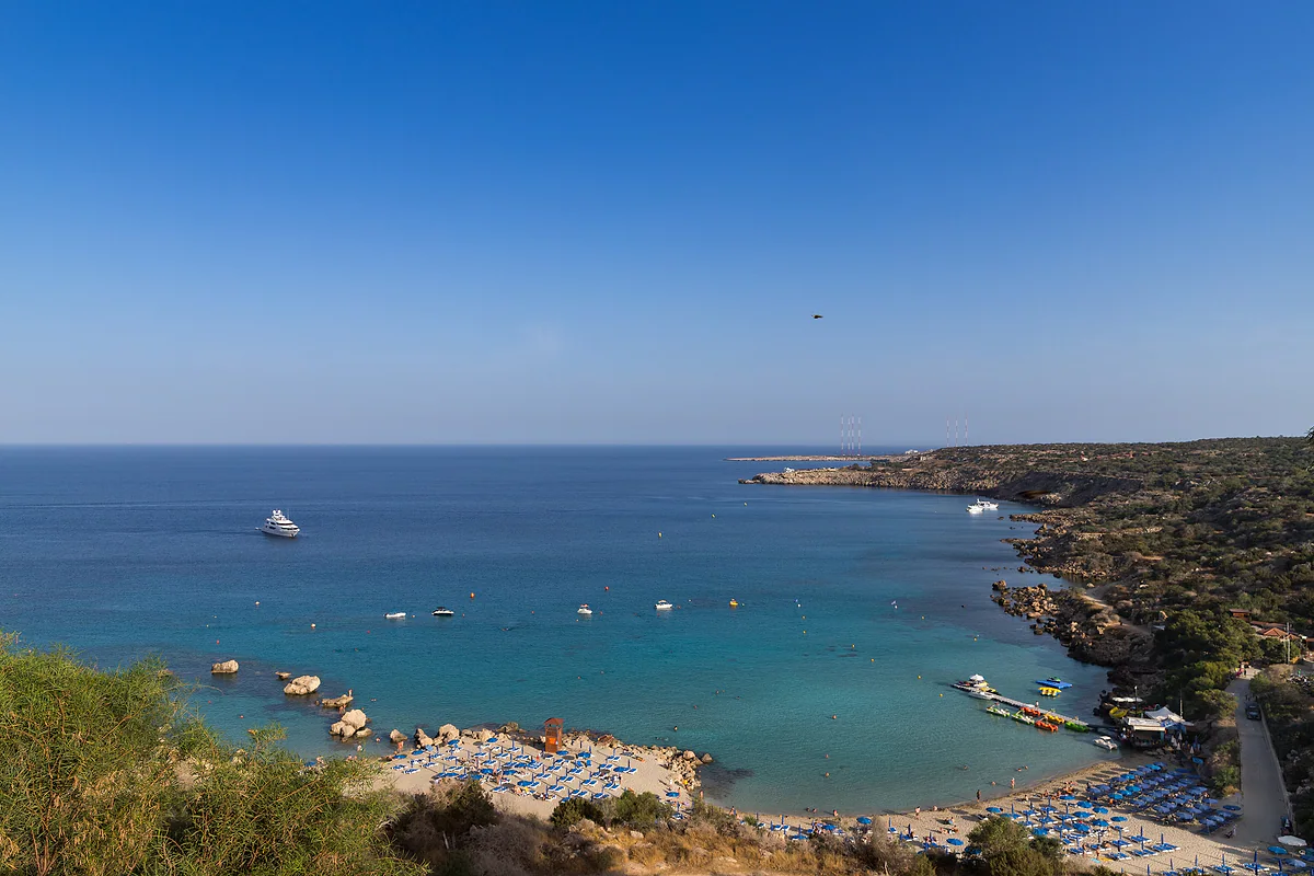 The Konnos coast and Cape Greco from above, with the beach, boats at anchor and blue sea stretching to the horizon