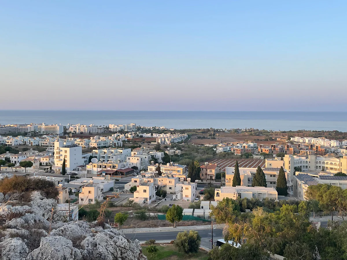 Protaras from the hill of Profitis Ilias, with white houses, hotels and the sea in the distance in the evening light