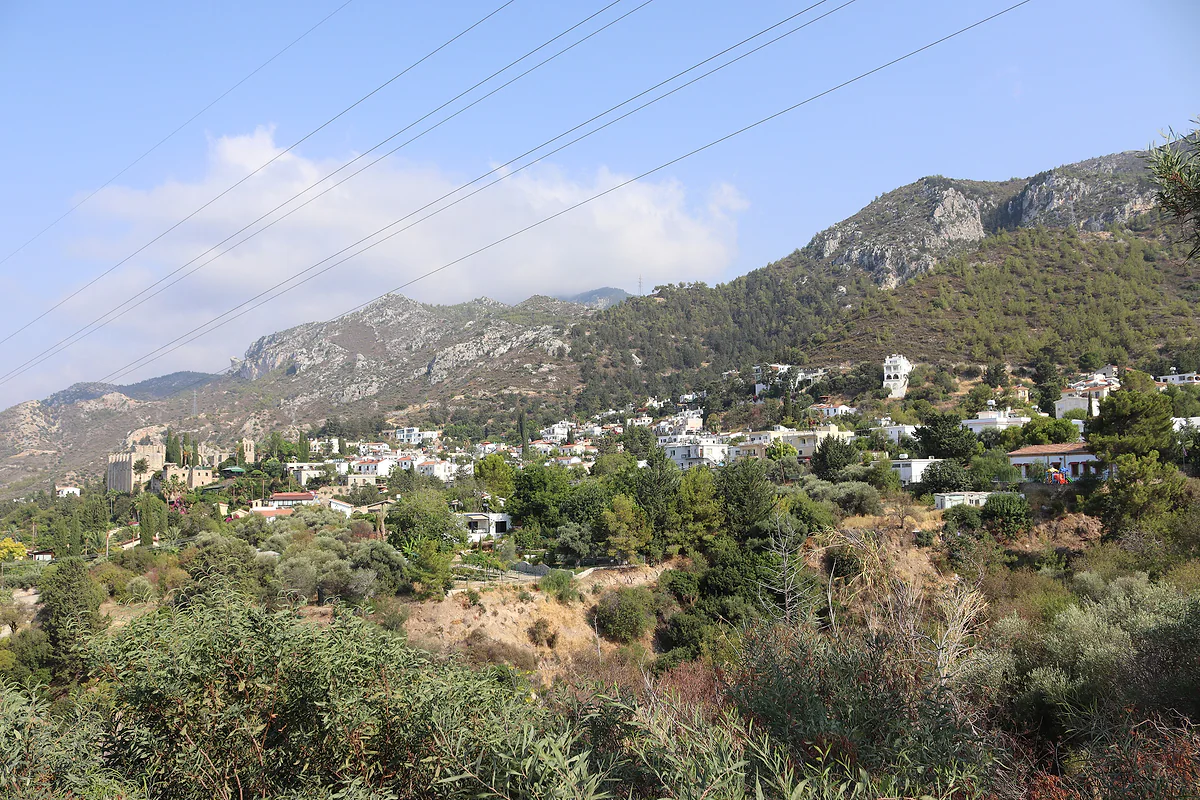 Bellapais village on the slopes of the Kyrenia range, with white houses among trees and the abbey on the left