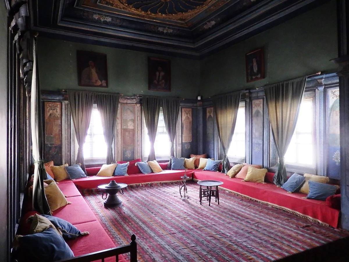 The Ottoman reception room in the House of Hadjigeorgakis Kornesios, with red divans, rugs and a painted wooden ceiling