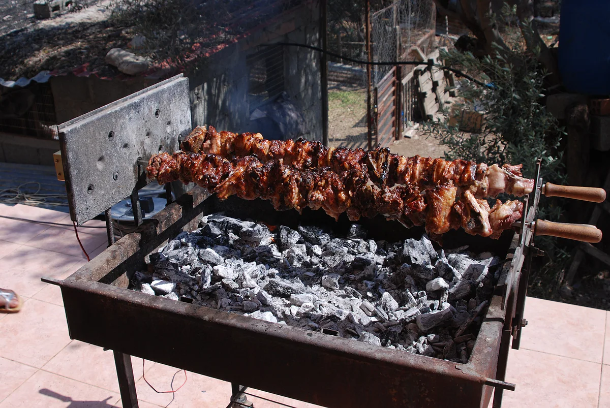 Souvla roasting on skewers over the embers of a charcoal grill, the typical festive barbecue in Cyprus