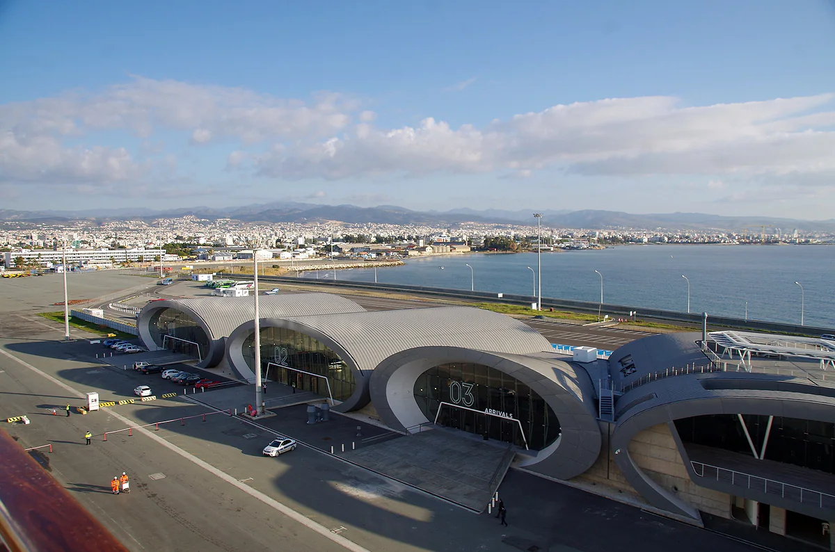 The cruise terminal at the port of Limassol, with its curved roofs beside the quay and the city behind