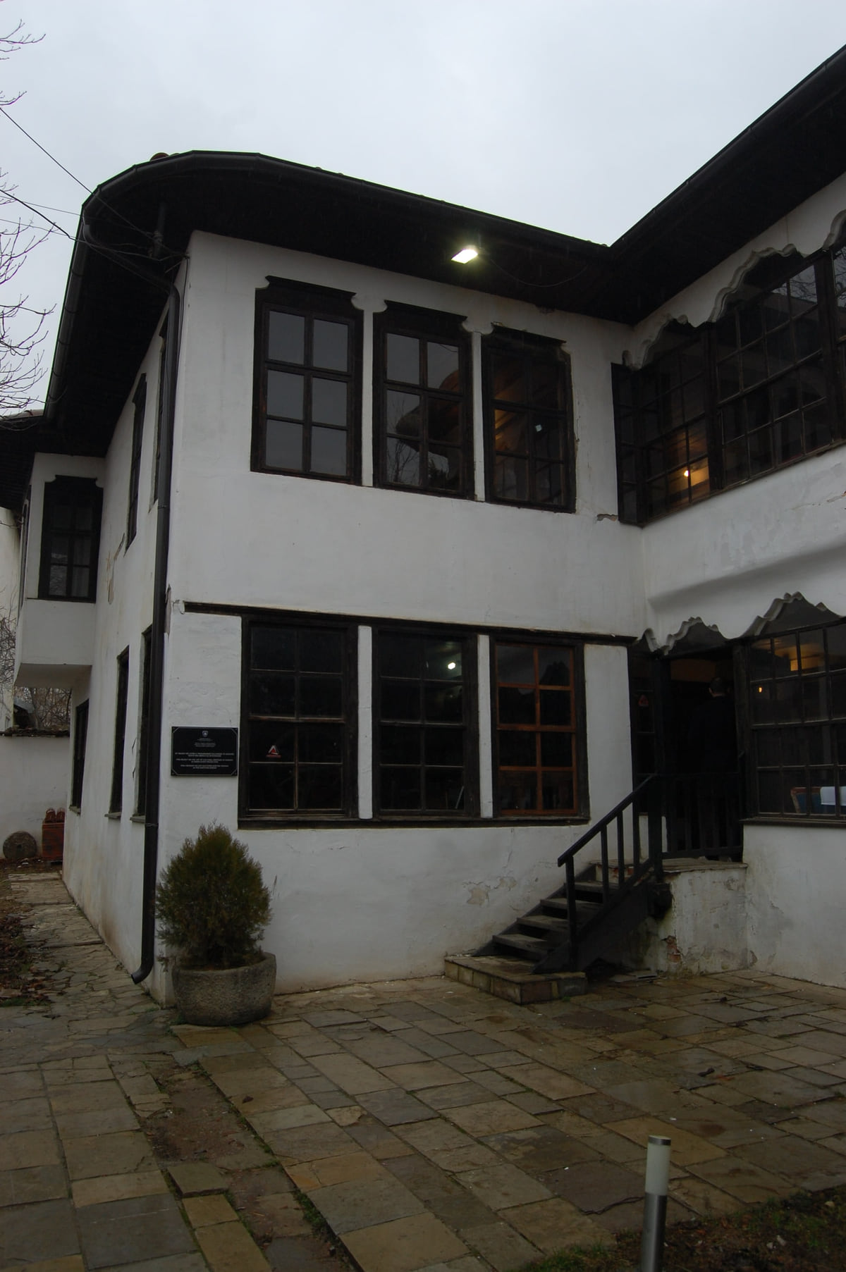 The courtyard of the Emin Gjiku Ethnological Museum in Pristina, a whitewashed Ottoman house with dark wooden windows