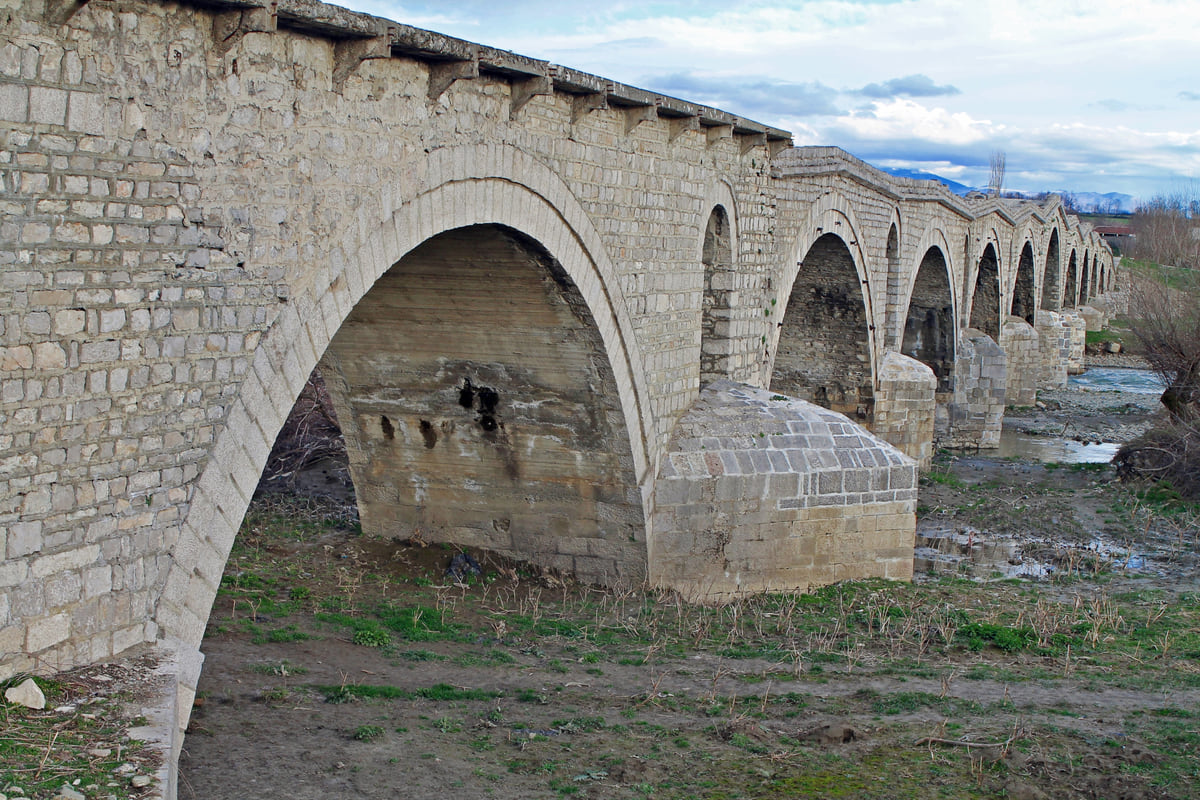 The Terzi stone bridge near Gjakova, with its main arch and the row of smaller arches crossing the riverbed