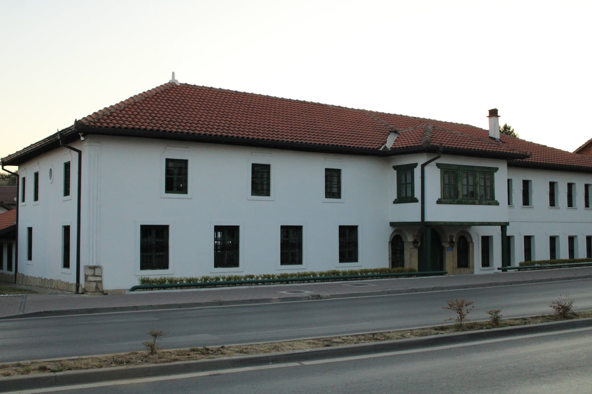 The white two-storey building of the Sheh Danjolli tekke in Gjakova, with a red tiled roof and dark windows