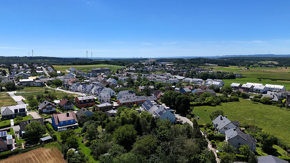 The village of Contern seen from above, with houses, gardens and fields stretching to the horizon