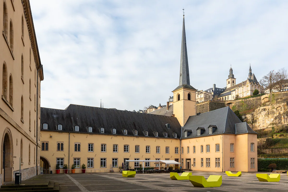 The courtyard of Neumünster Abbey with the bell tower of St John's and the upper town on the rock behind