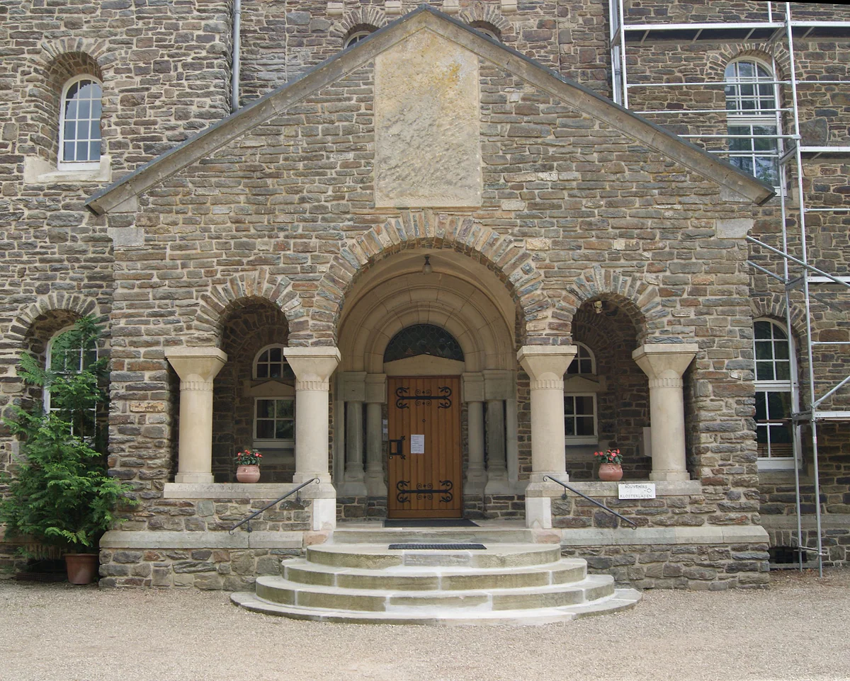 The Romanesque portico of the Abbey of Saint-Maurice in Clervaux, with arches on columns and stone walls