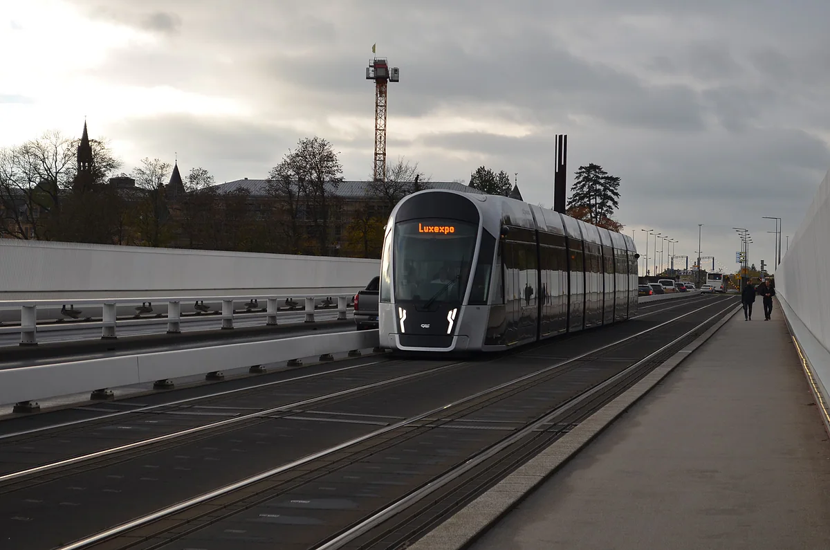 A line T1 tram bound for Luxexpo crossing the Grand Duchess Charlotte Bridge under a grey sky