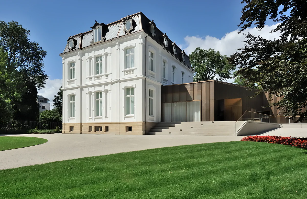Villa Vauban, the city's art museum, with its white façade, modern extension and the lawn of the park