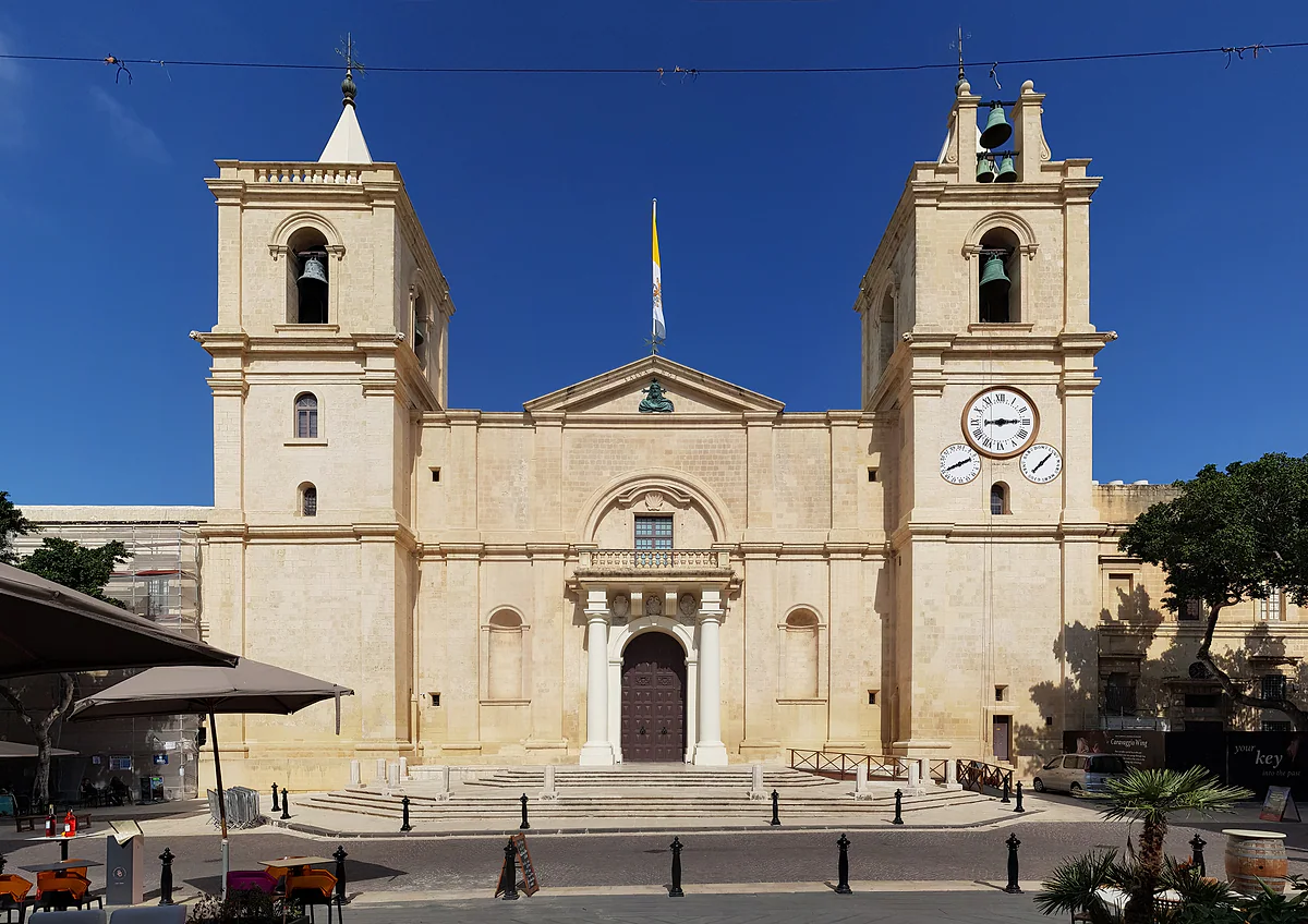 La sobria fachada de la concatedral de San Juan de La Valeta, con sus dos campanarios, el reloj y la escalinata de la plaza de San Juan.