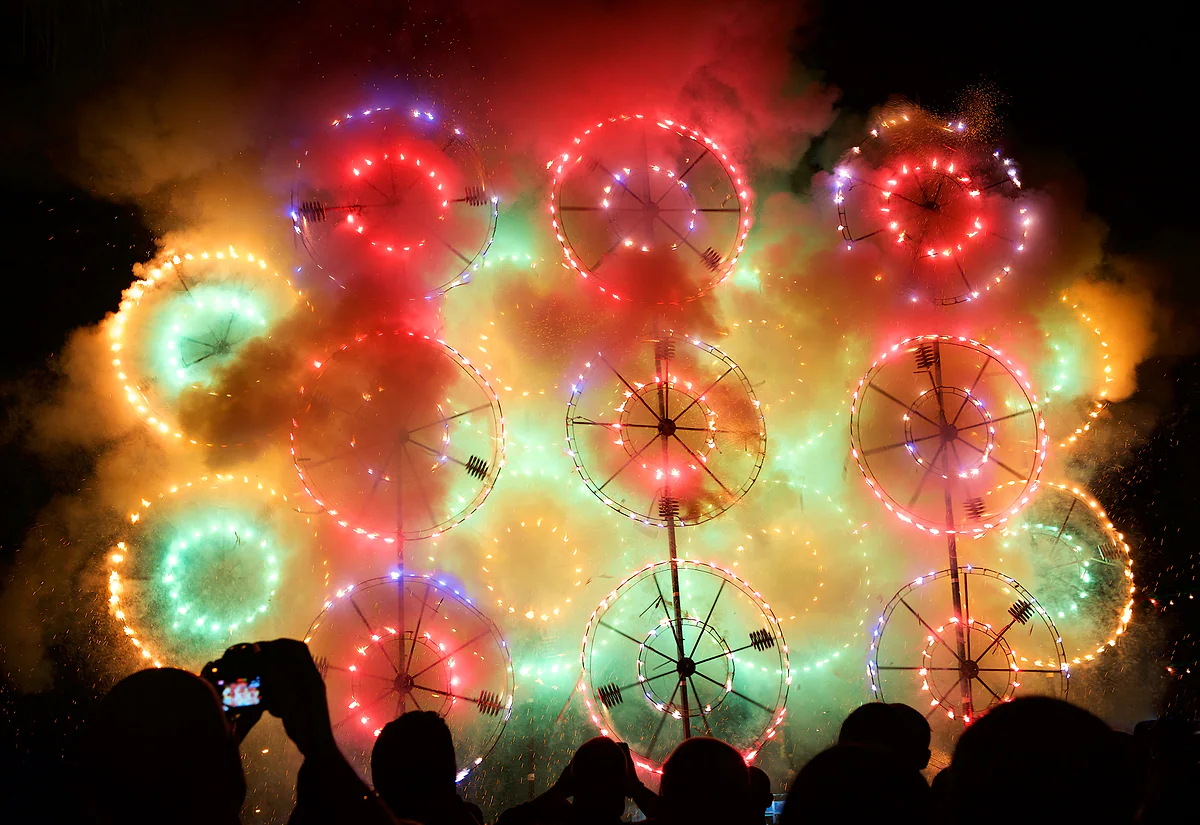 Las ruedas giratorias de los fuegos de tierra, el ġigġifogu, llenando la noche de luz y humo ante el público de una festa maltesa.