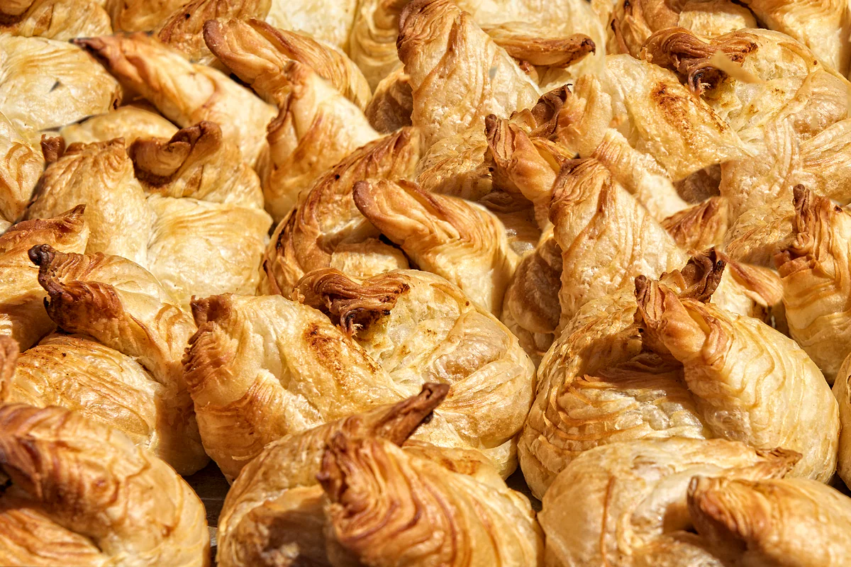 Una bandeja de pastizzi recién horneados, los hojaldres malteses rellenos de requesón o de guisantes, dorados y crujientes.