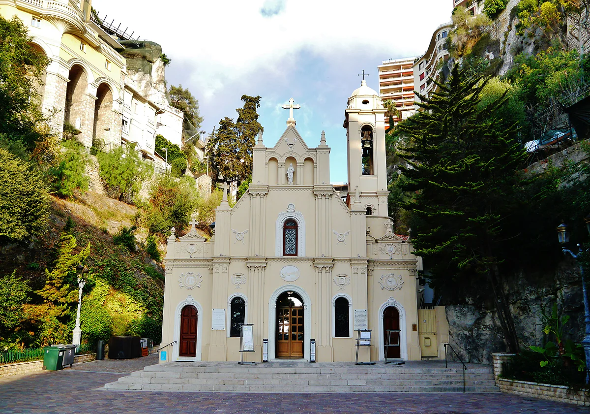 La iglesia de Santa Devota, de fachada clara y campanario, al pie del barranco de los Gaumates.