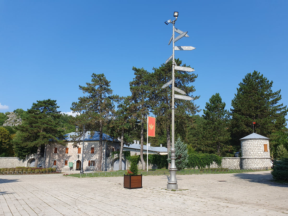 The Biljarda in Cetinje, Njegoš's residence, with its stone wall, a round corner tower and pine trees in front of the square