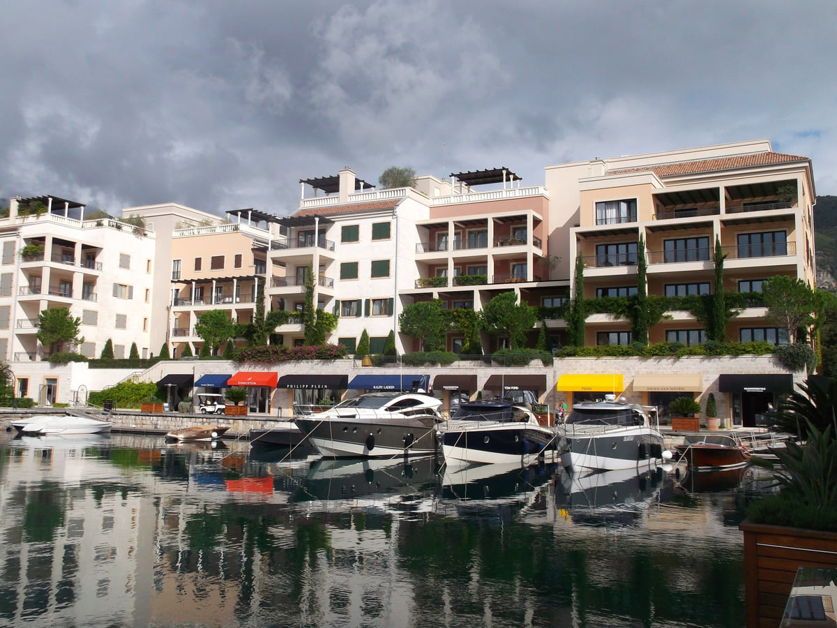 The Porto Montenegro marina in Tivat, with motorboats moored in front of pale apartment buildings on the waterfront