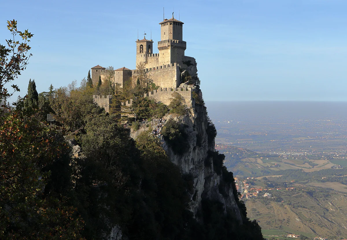 La Guaita, primera torre de San Marino, sobre su peñasco de roca con la muralla almenada y la llanura hacia el Adriático al fondo.