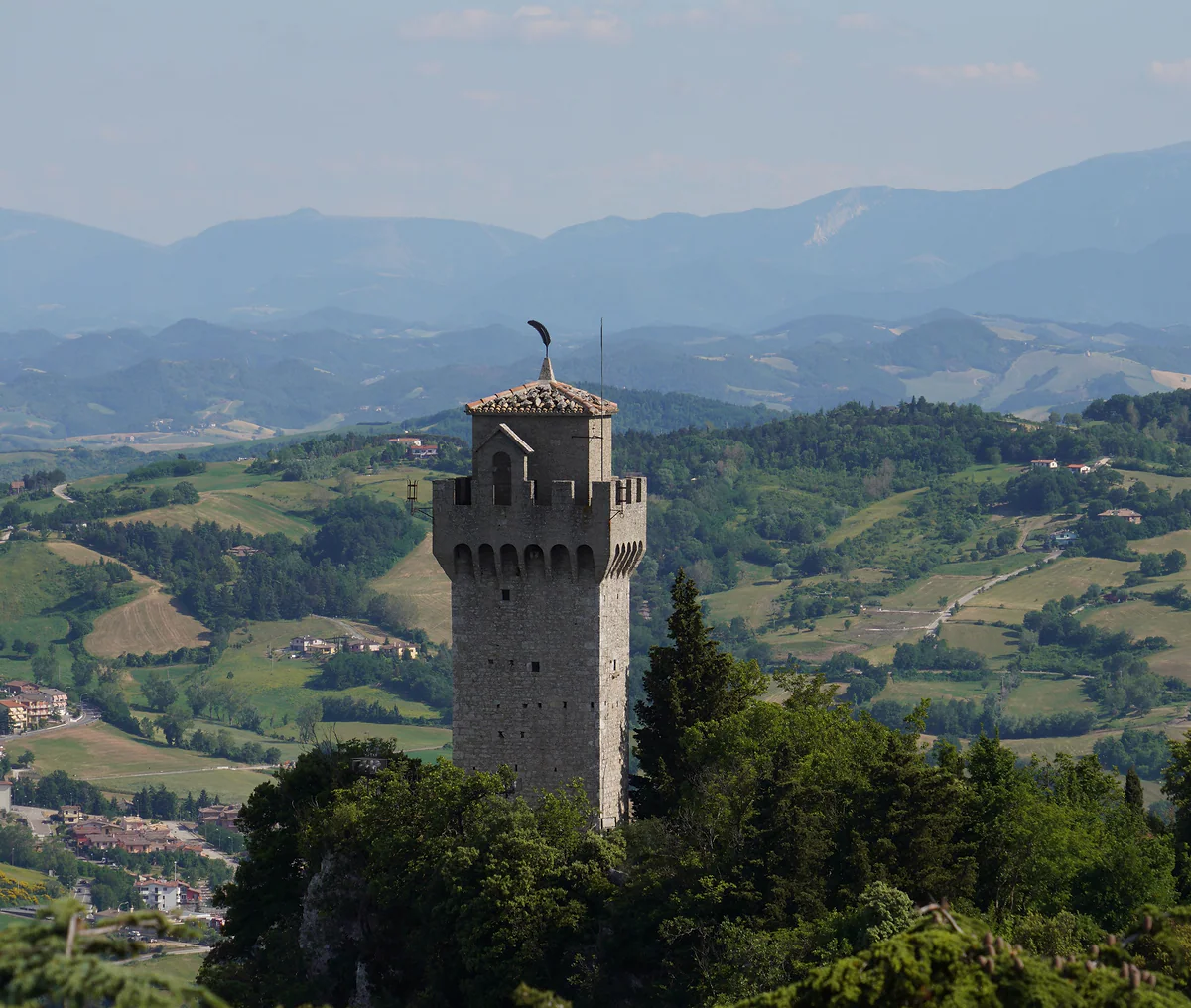 La Montale, tercera torre, de planta pentagonal, entre el bosque del Titano con las colinas y los Apeninos detrás.