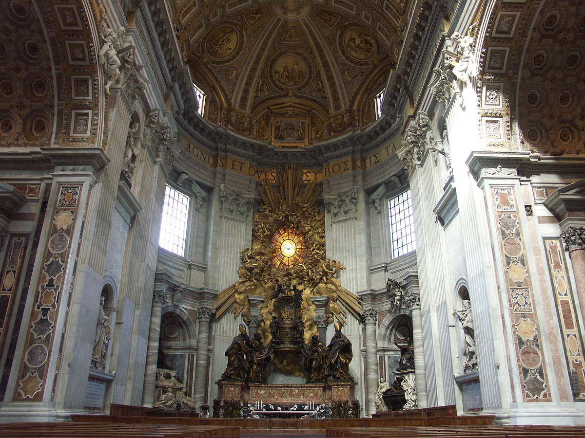 La Cátedra de San Pedro de Bernini al fondo del ábside de la basílica, con la vidriera de la paloma encima y el bronce dorado.