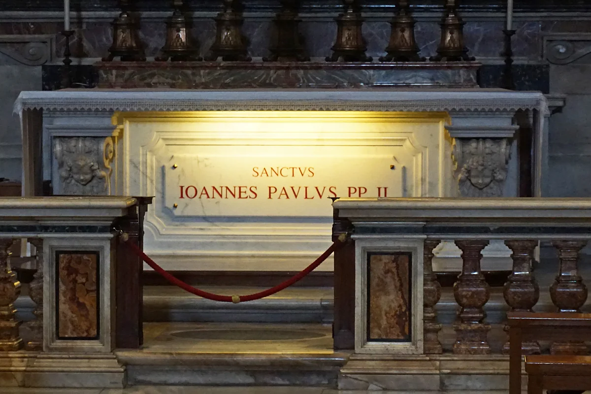La tumba de san Juan Pablo II en la capilla de San Sebastián de la Basílica de San Pedro, con la losa de mármol y su nombre en latín.